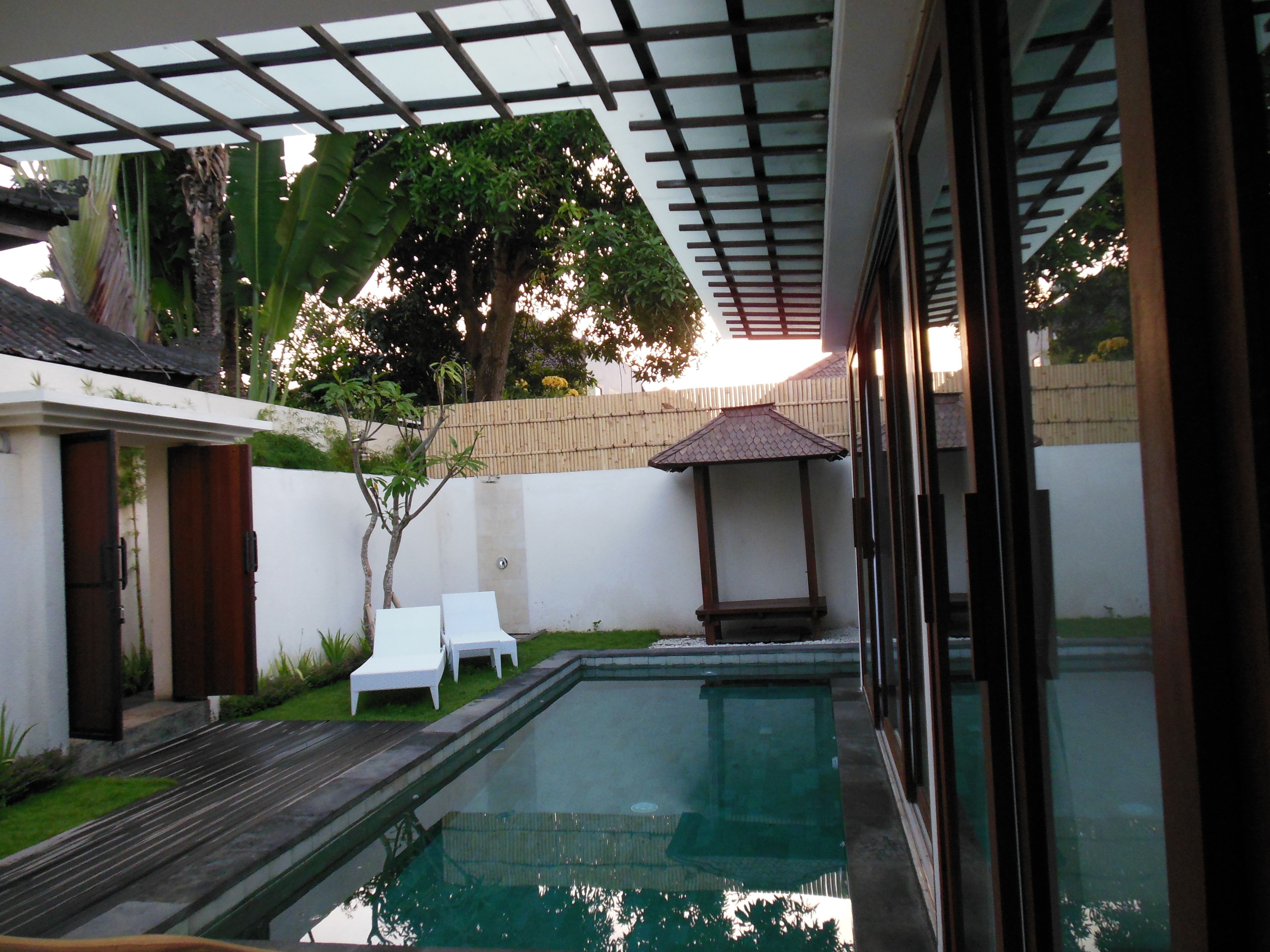Une piscine surmontée d’une pergola, un petit jardin agrémenté d’un banc et une vue sur les environs.