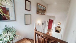 A staircase with wooden railings and a potted plant on the left.