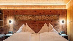 Ein Schlafzimmer mit Holzboden, einem Bett mit weißer Bettwäsche, zwei Nachttischen und Wandlampen.