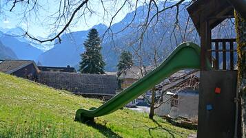 Explore the great outdoors at this mountain playground with a green slide and scenic views.