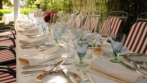 Ein Tisch, gedeckt für eine Mahlzeit, mit mehreren Weingläsern, Tellern und Besteck.