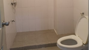 A small, white-walled bathroom with a shower and toilet. - OYO 75414 KJS Pattaya (Pattaya)