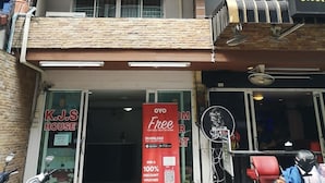 A multi-story building with a ground-level entrance, a balcony with a metal railing, and a sign for 'K.J.S HOUSE'. - OYO 75414 KJS Pattaya (Pattaya)