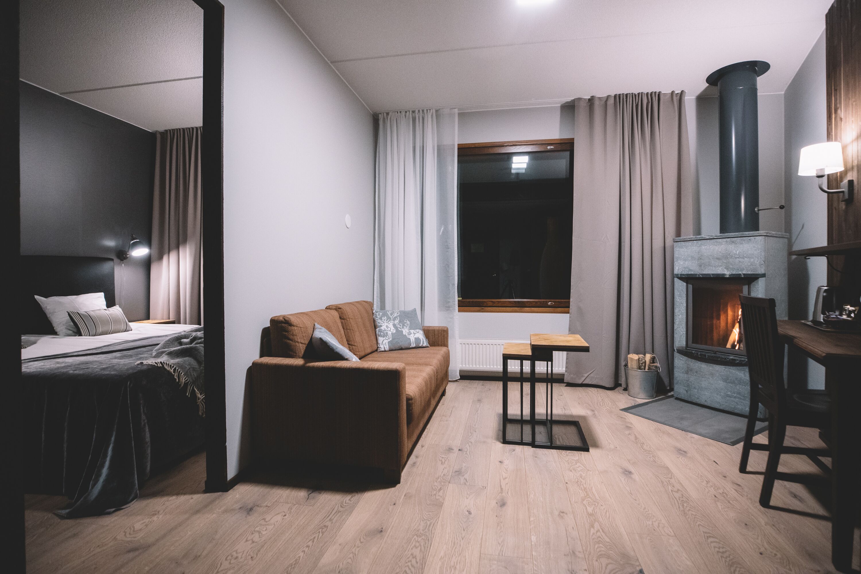 Una camera moderna con un letto, un divano, un camino e un'area pranzo.
