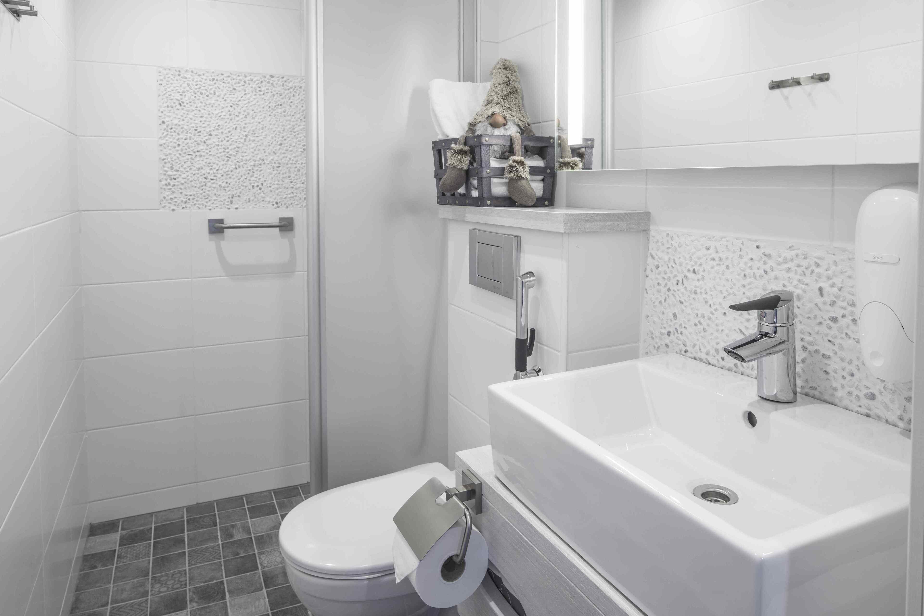 A modern bathroom with a toilet, sink, and shower.
