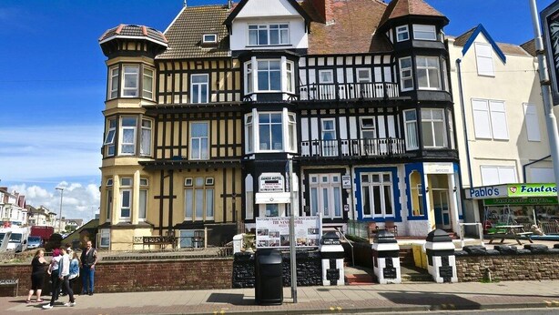 A row of multi-story buildings with a mix of architectural styles, including Tudor and Georgian elements. - The Sands Hotel (Blackpool)