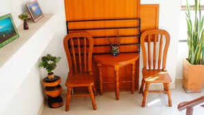 A staircase leading to a room with a wooden chair and a small table. - Vipa House (Chiang Mai)