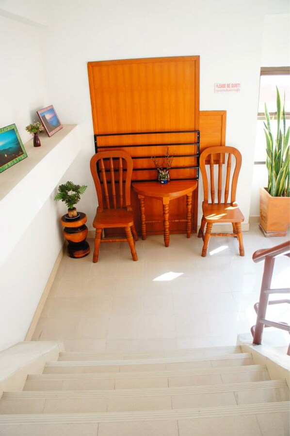 A staircase leading to a room with a wooden chair and a small table.