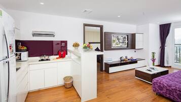 Uma sala moderna com área de cozinha, uma mesa de jantar e um sofá.