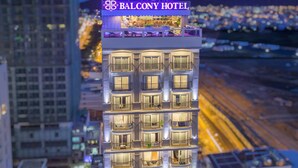 Un edificio alto con varios balcones y un letrero llamativo que dice "BALCONY HOTEL".