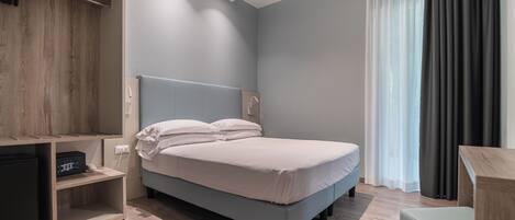 Quarto moderno com cama, escrivaninha e guarda-roupa.