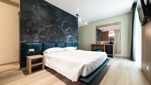 A modern bedroom with a large bed, a bedside table, a mirror, and a dark accent wall.