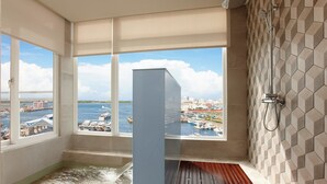 Un baño moderno con un ventanal grande, una bañera y una ducha.