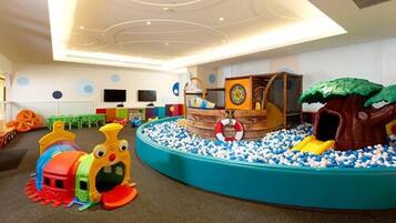 Kids can play and explore in this vibrant play area featuring a ball pit, ship-shaped play structure, and slide.