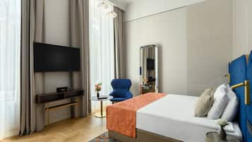 Una habitación de hotel moderna con una cama grande, un televisor de pantalla plana, un escritorio y una silla.