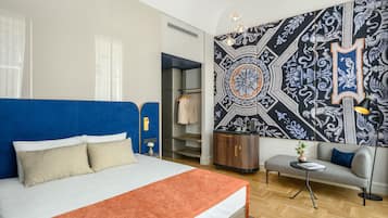 Une chambre d’hôtel moderne avec un grand lit, un canapé, une petite table et une armoire.