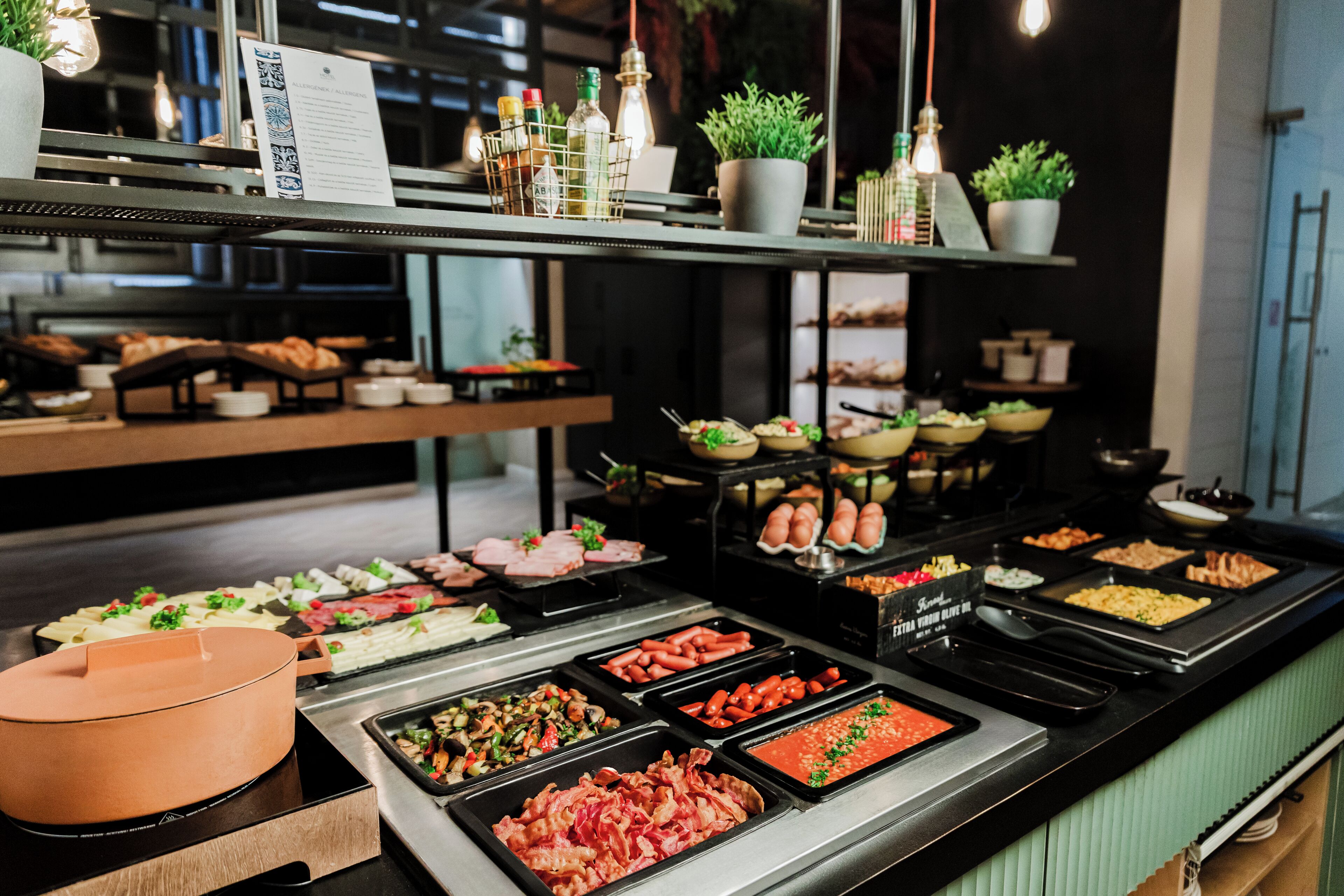 Un bufé con diversas opciones de comida, incluyendo carnes, verduras y ensaladas.