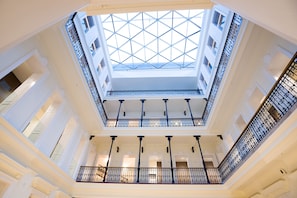 Un atrio de varios niveles con techo de vidrio y balcones.