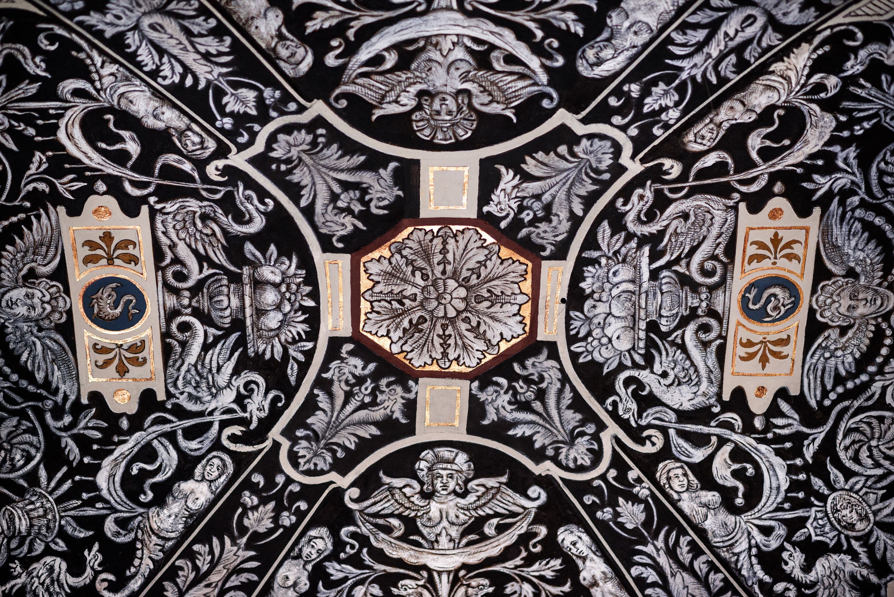 A detailed ceiling with intricate black and white patterns, including floral and geometric designs.