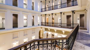 A multi-level atrium with a central staircase, columns, and balconies. - Hotel Moments Budapest (Budapest)