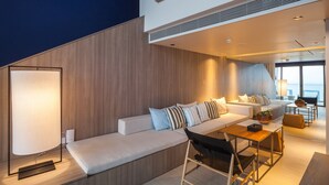A modern interior with a sofa set, a dining table, and a large window offering a view. - Veranda Resort Pattaya MGallery (Pattaya)