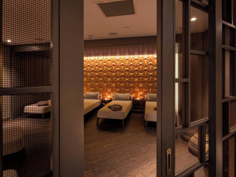 Une chambre d’hôtel avec un mur à carreaux, un mur à motifs et un lit avec des oreillers.