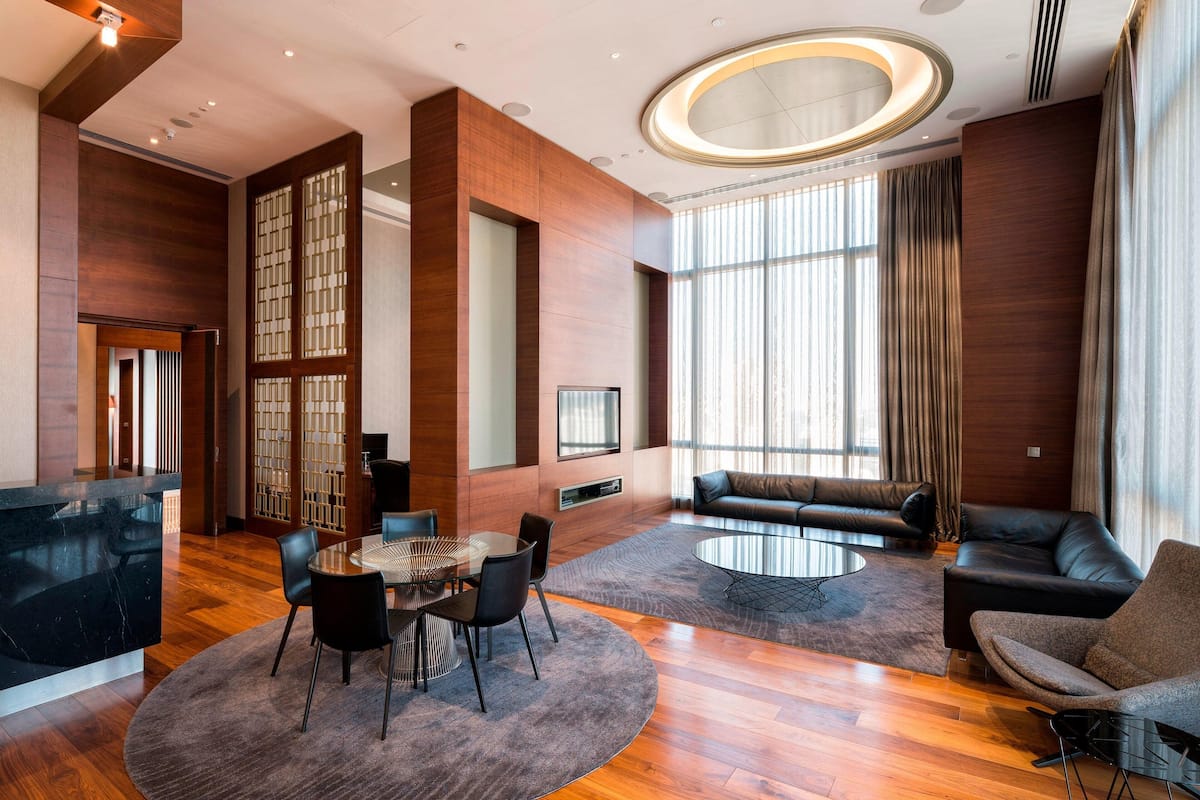 Eine moderne Hotelhalle mit einer Rezeption, einer Sitzecke und großen Fenstern.