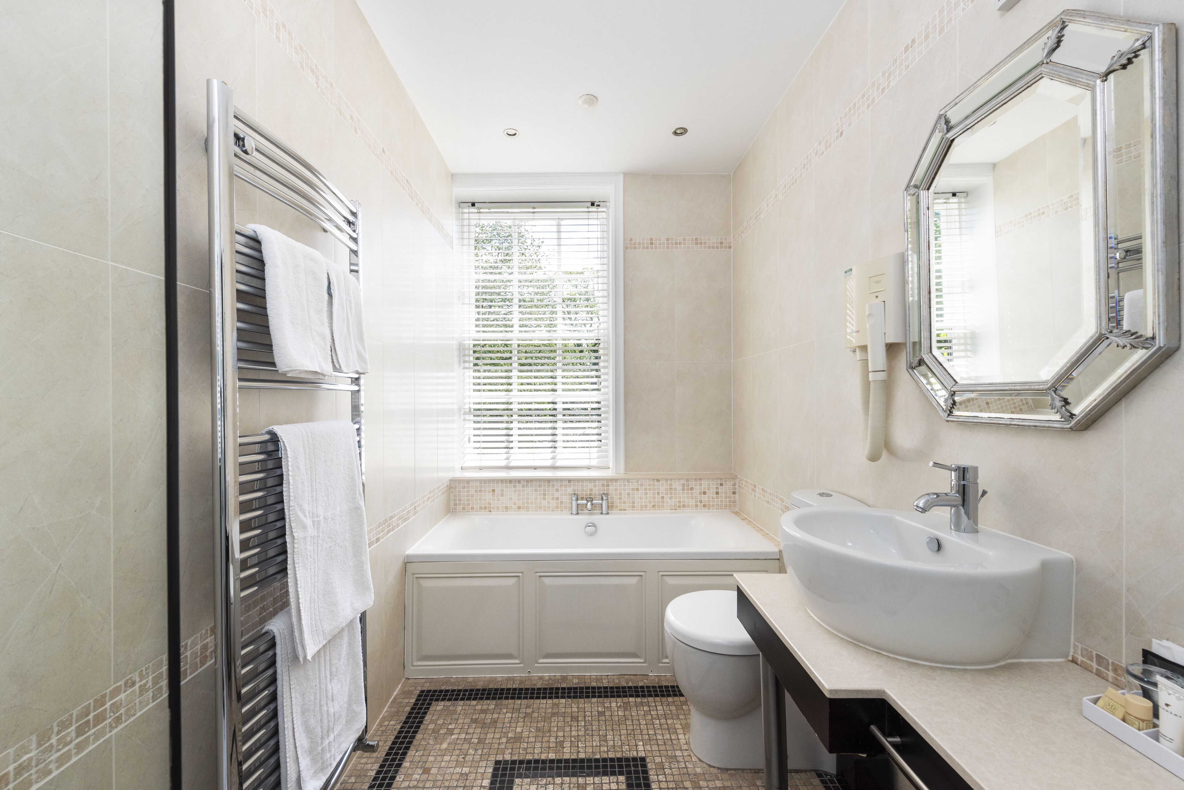 A modern bathroom with a bathtub, toilet, and sink.
