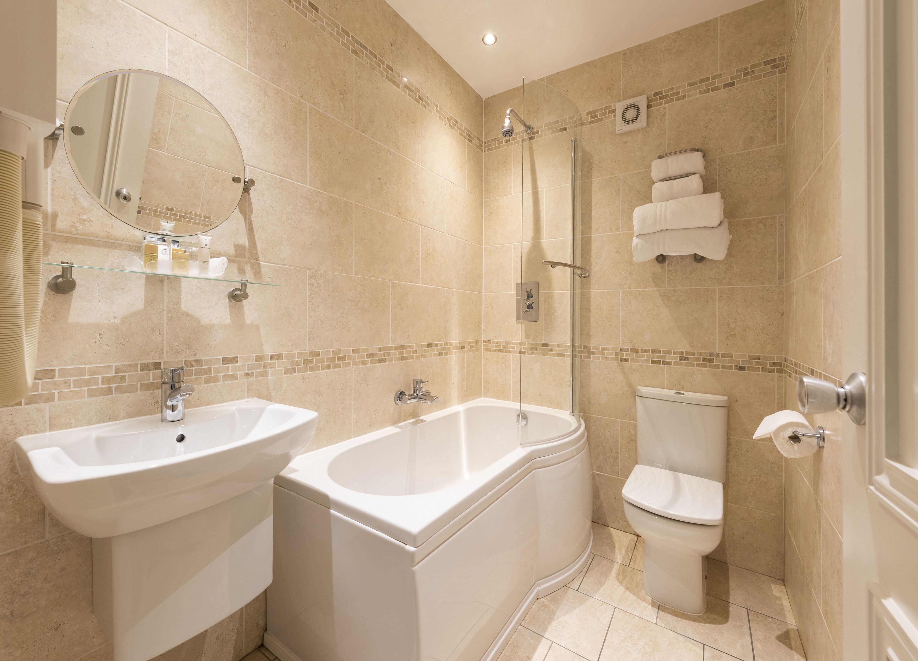 Un baño con dos lavamanos, una bañera, un inodoro y una ducha.