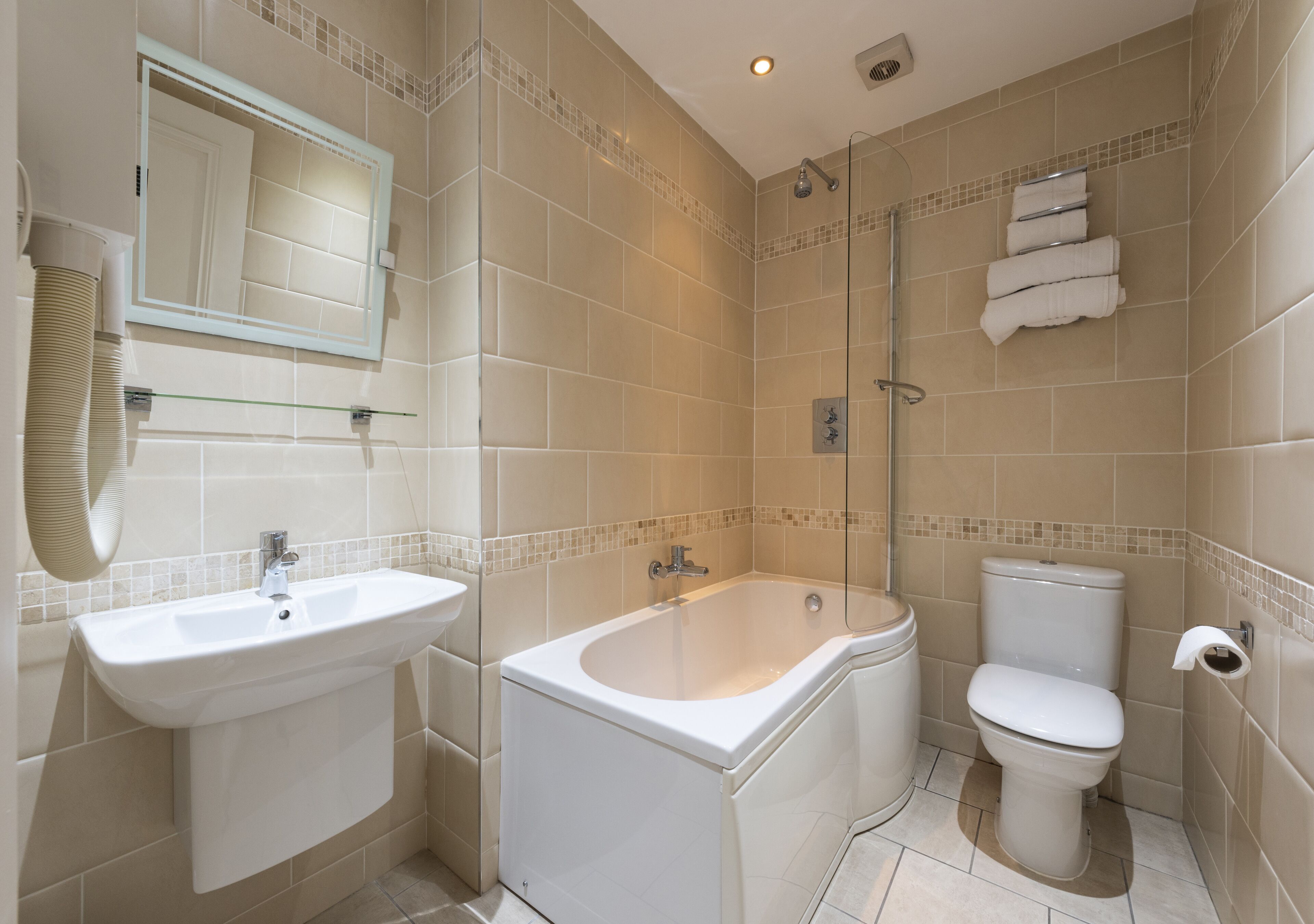 A bathroom with a sink, bathtub, toilet, and a glass-enclosed shower.