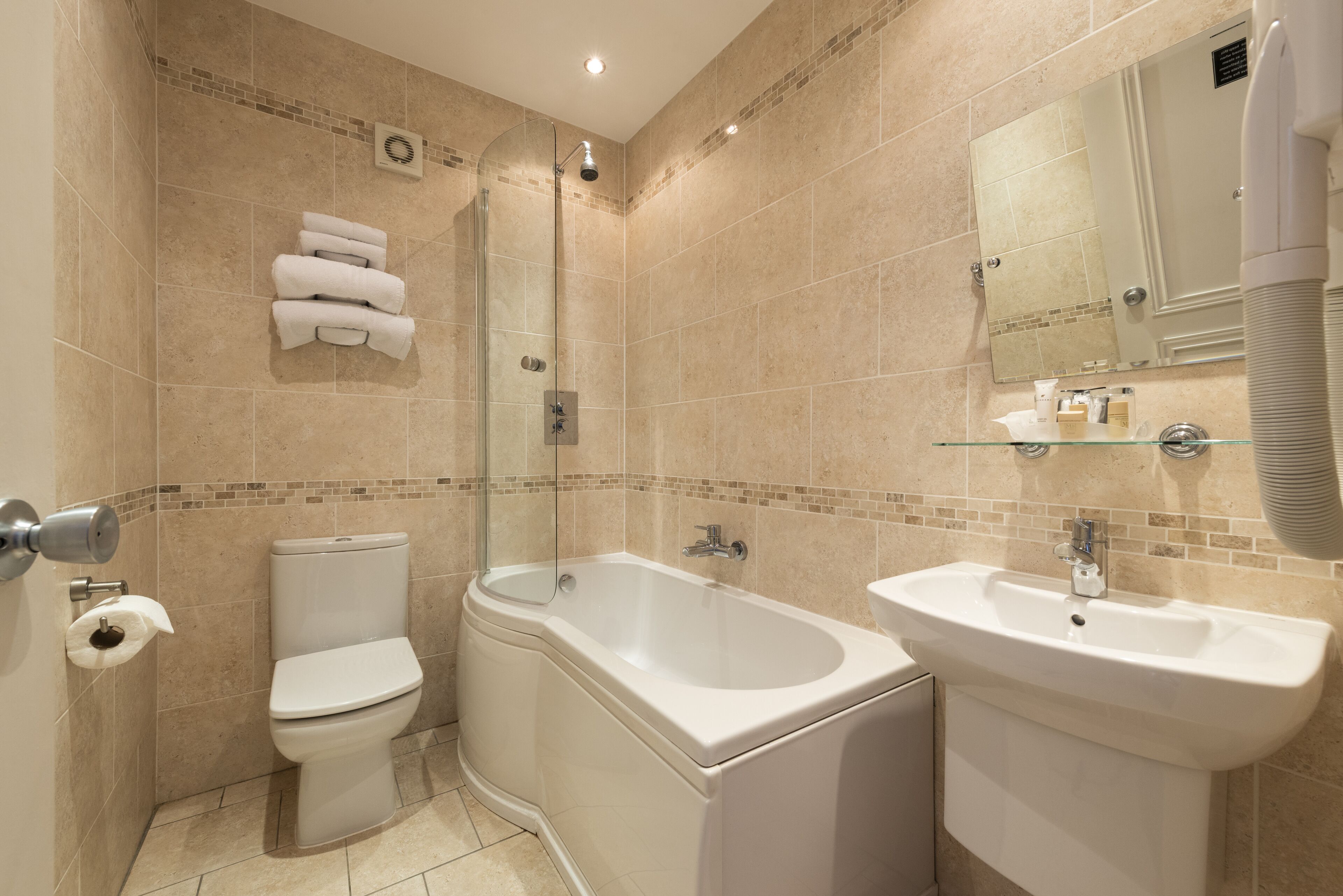 A modern bathroom with a toilet, bathtub, and sink.