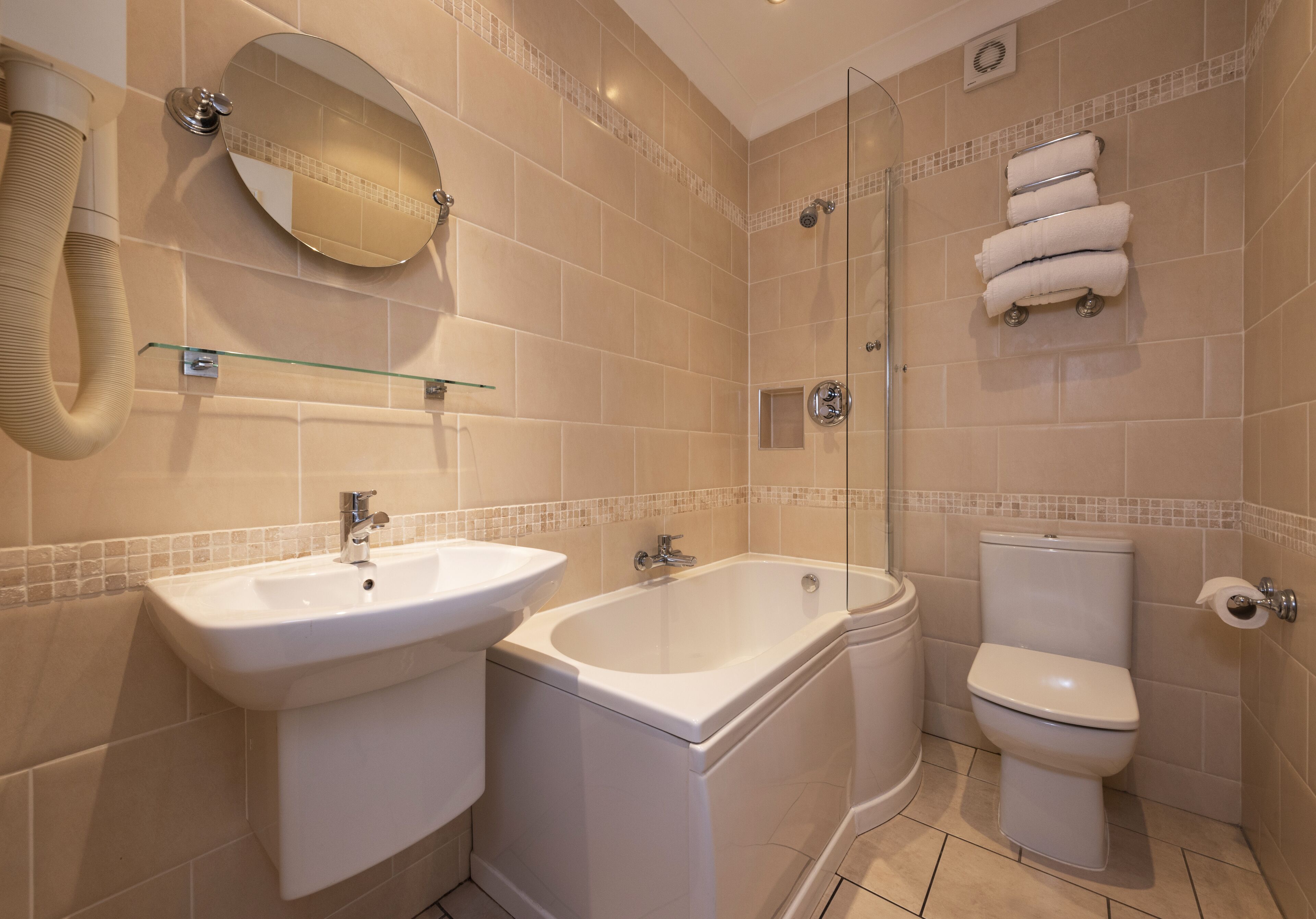 A modern bathroom with a sink, bathtub, toilet, and a glass shower enclosure.