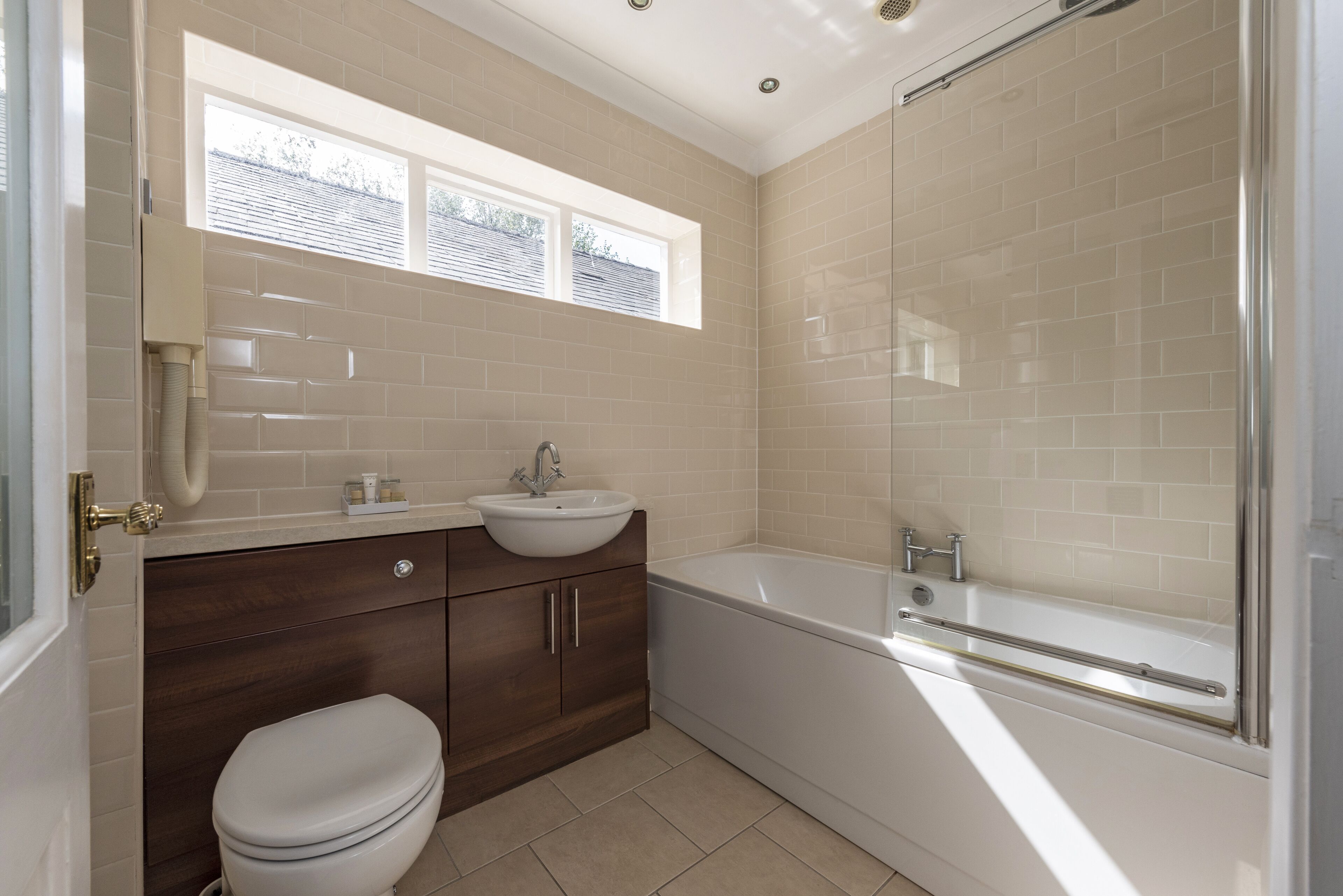 A bathroom with a toilet, sink, vanity, and bathtub.