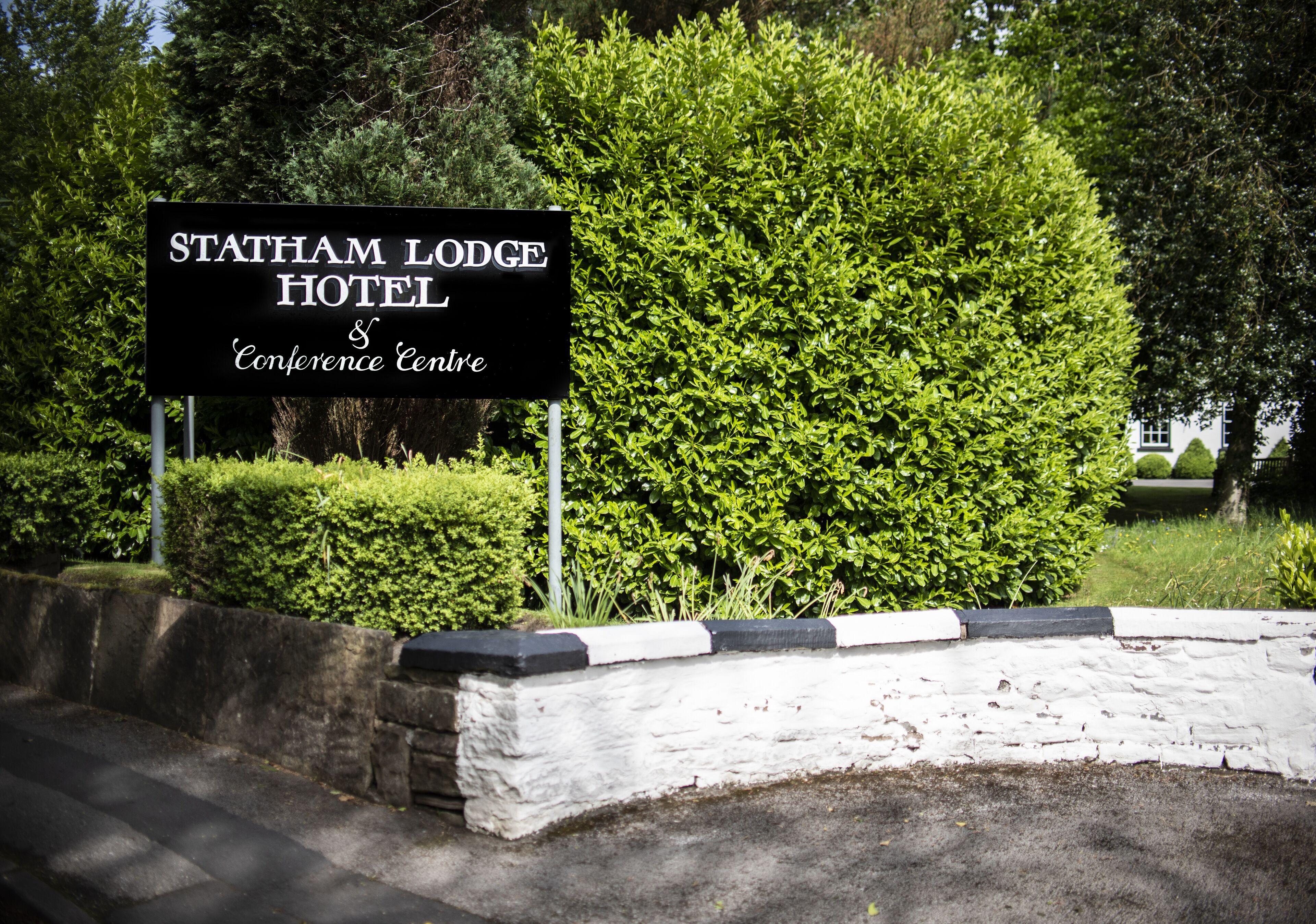 En skylt för Statham Lodge Hotel & Conference Centre.