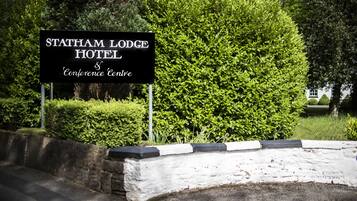 En skylt för Statham Lodge Hotel & Conference Centre.