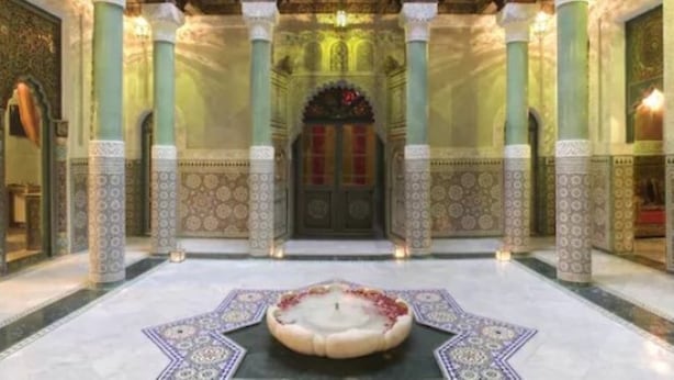 An ornate interior with a central fountain, high decorative columns, and intricate wall patterns. - Riad Mumtaz Mahal (Essaouira)