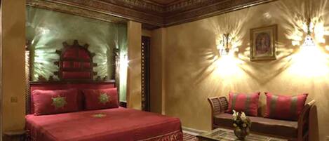 A traditional room with a large bed, a sofa, and a coffee table.