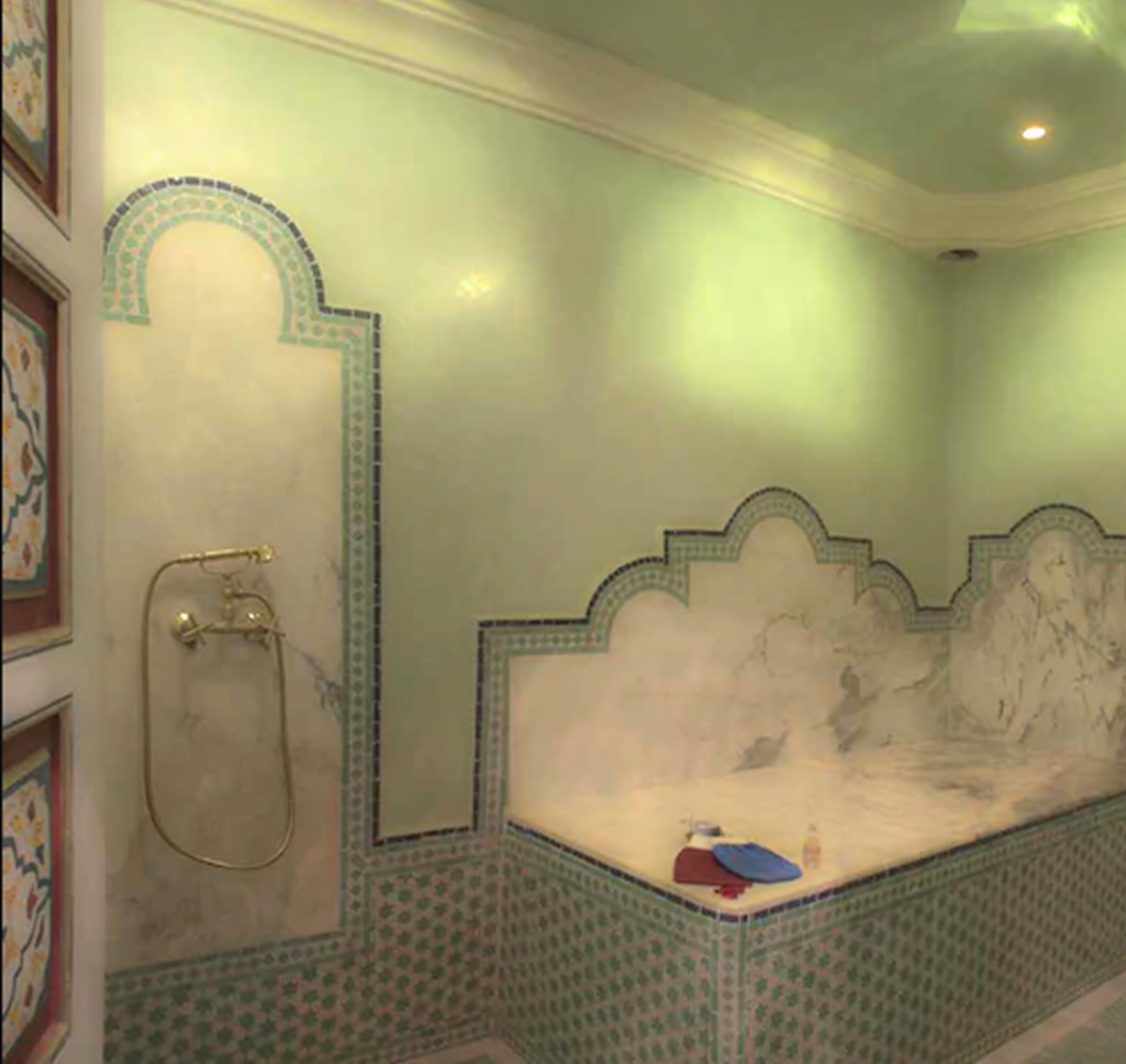Un baño con bañera, ducha e inodoro. Las paredes están decoradas con azulejos estampados.