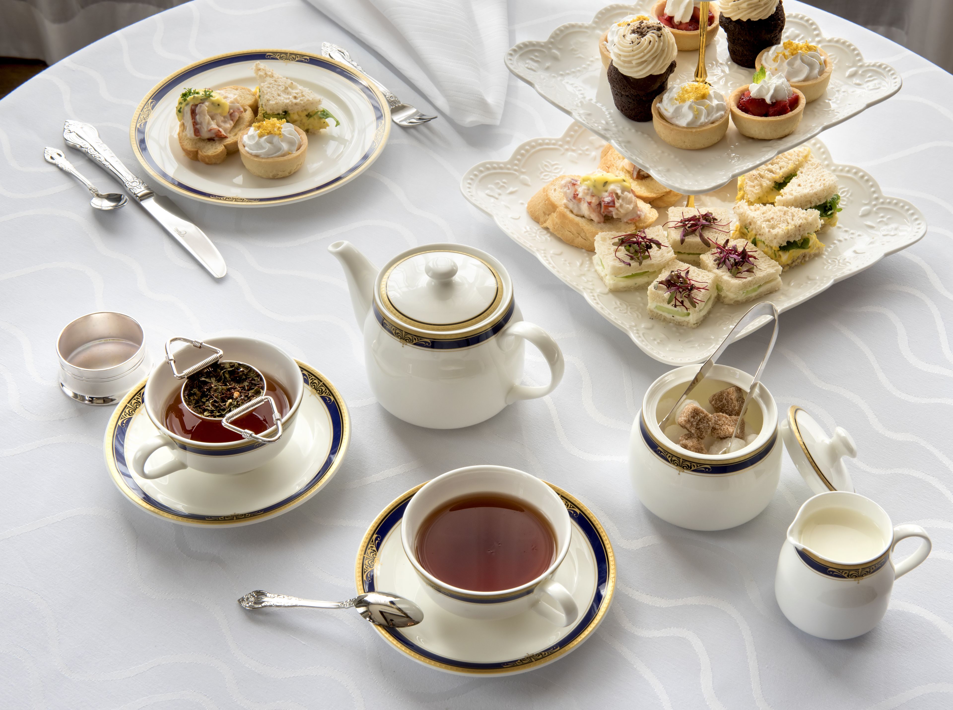 A tea service set with a teapot, cups, and a sugar bowl on a table.