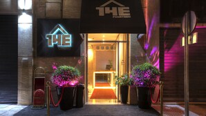 A hotel entrance with a neon sign, a red carpet, and potted plants. - The Fourteen Luxury Boutique Hotel & Spa (Casablanca)