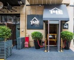 La entrada del The Fourteen Boutique Hotel & Spa, con una fachada moderna, alfombra roja y plantas en macetas.