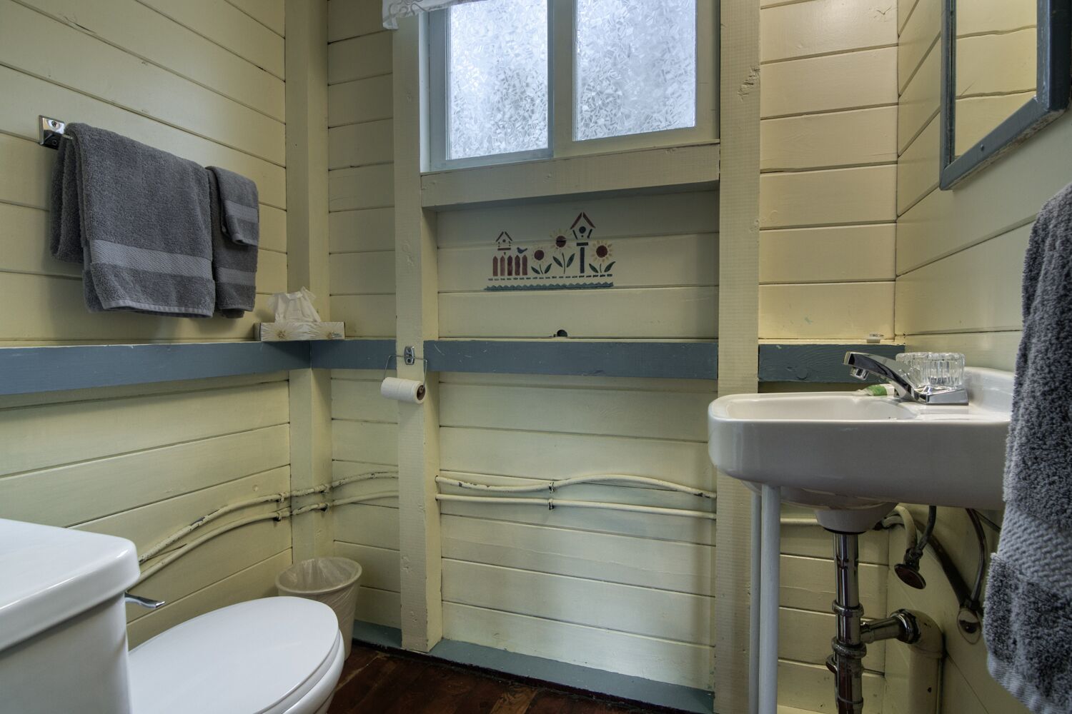 Baño pequeño con inodoro, lavamanos y ventana.