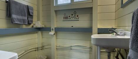 Baño pequeño con inodoro, lavamanos y ventana.