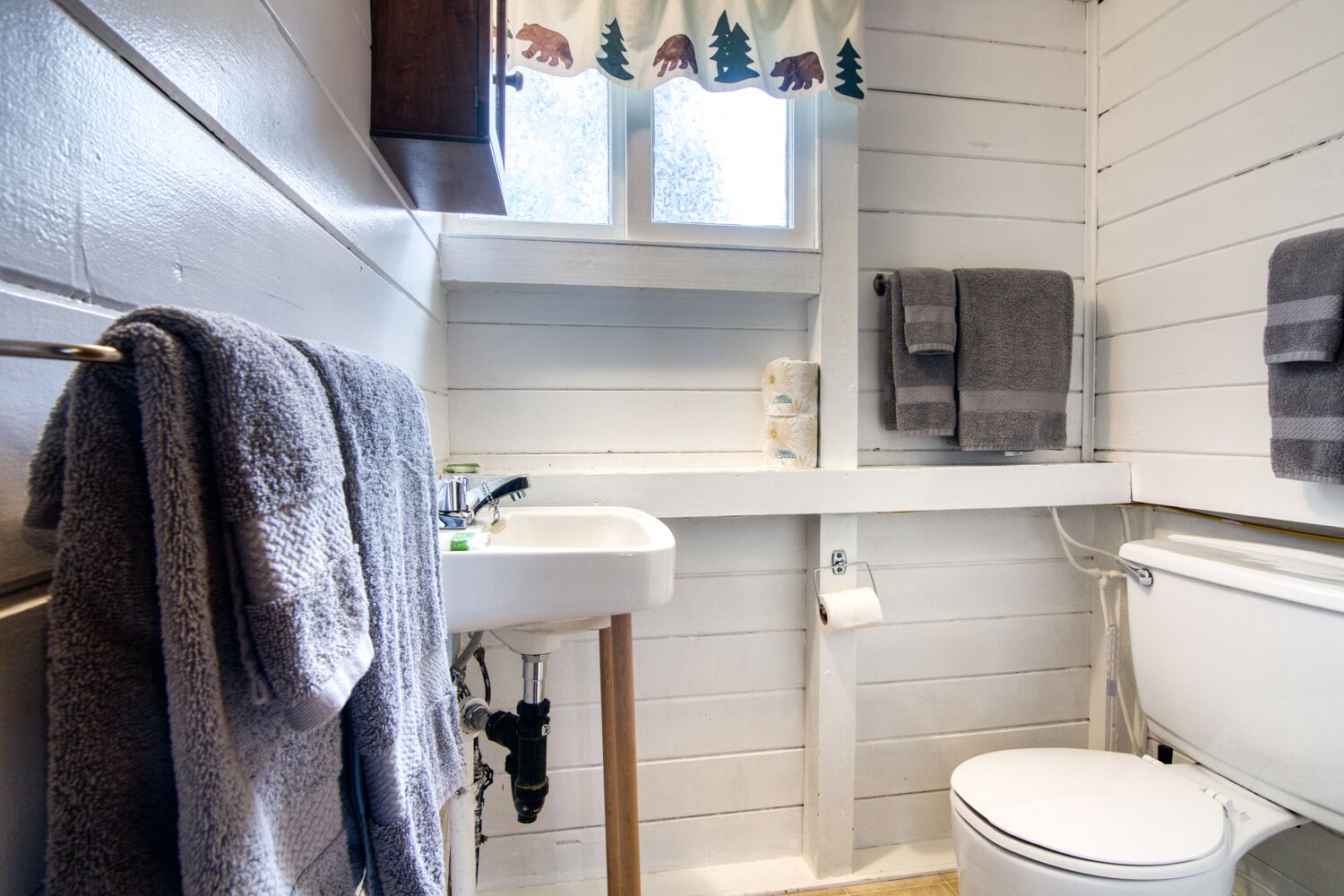 Une salle de bain avec un lavabo blanc, des toilettes et un porte-serviettes.