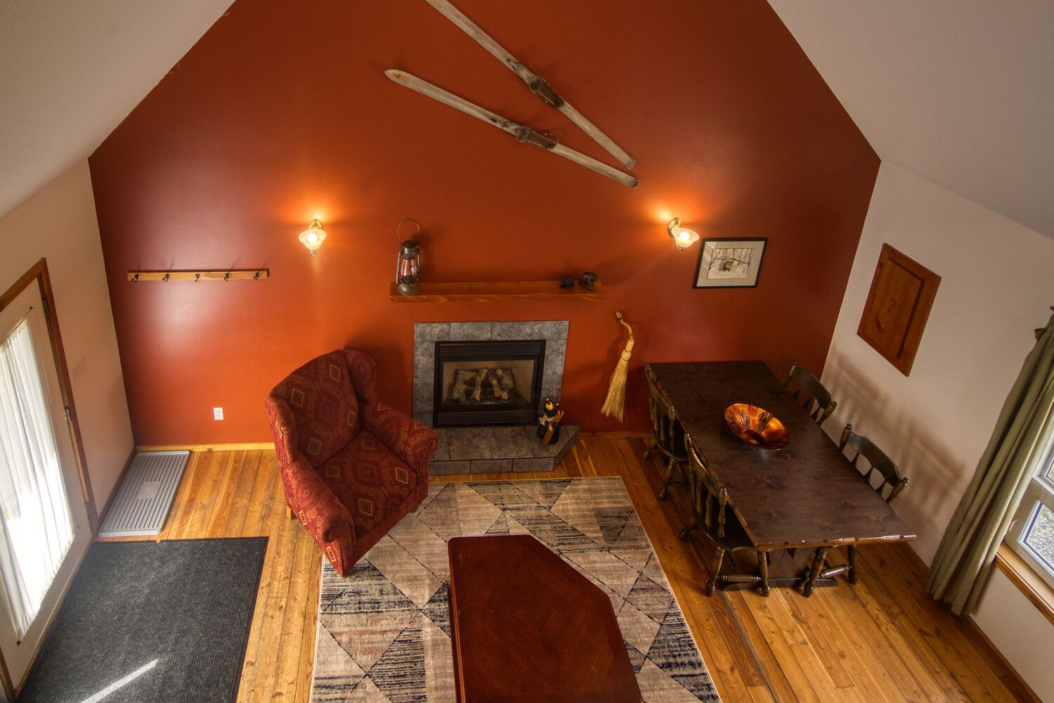 A cozy room with a fireplace, wooden furniture, and a red accent wall.
