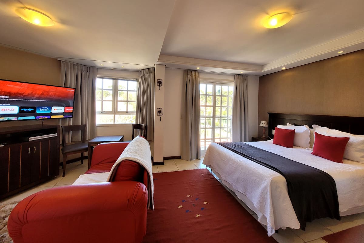 Une chambre d’hôtel avec un lit, une télévision, un bureau et une chaise.