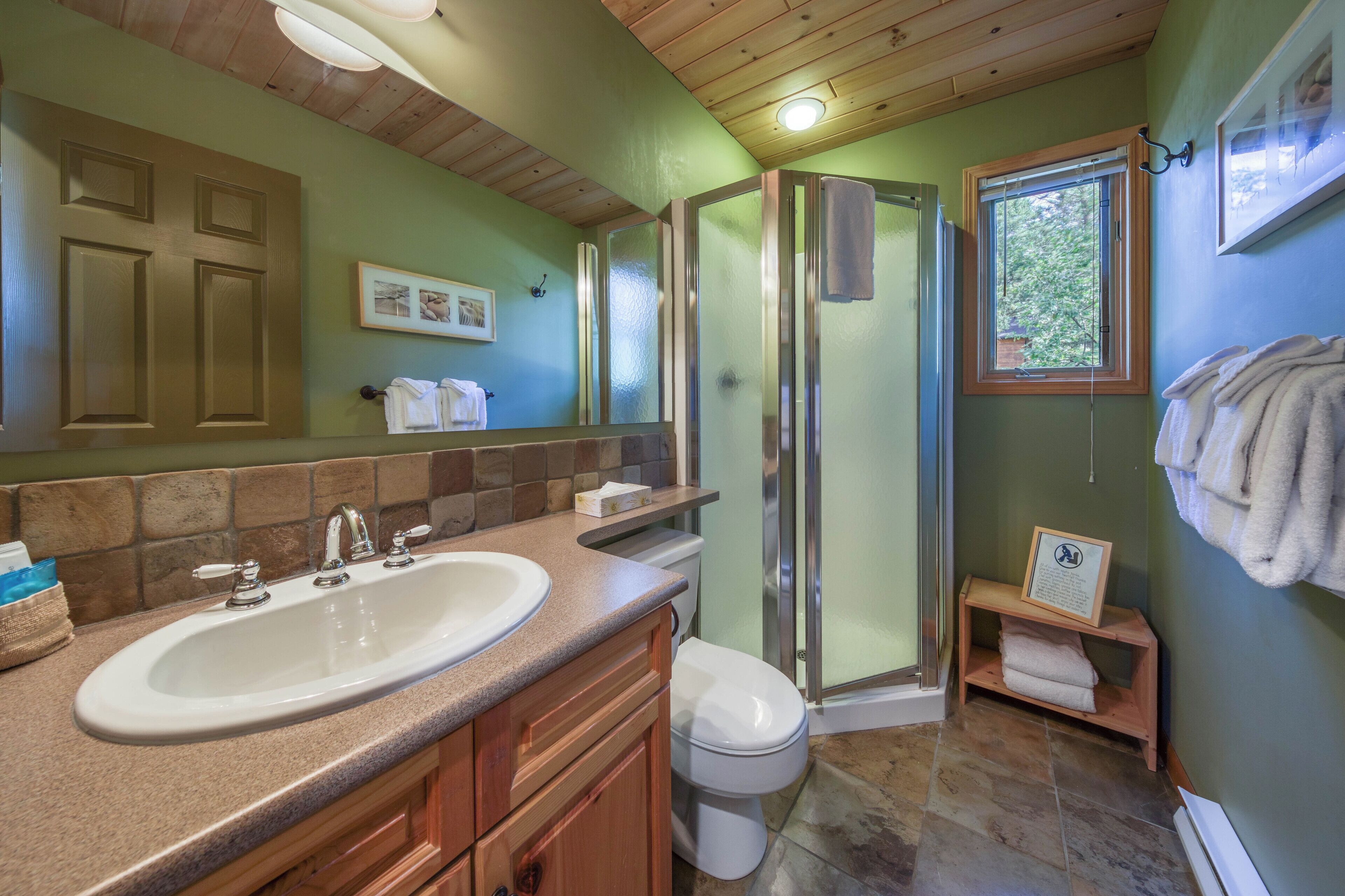 A bathroom with a sink, toilet, and shower.