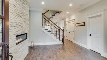 Ein geräumiger Flur mit einer Holztreppe, einem Kamin und einem Schild mit der Aufschrift 'Welcome to Chicago'.