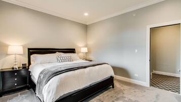 A bedroom with a bed, nightstands, and a door.