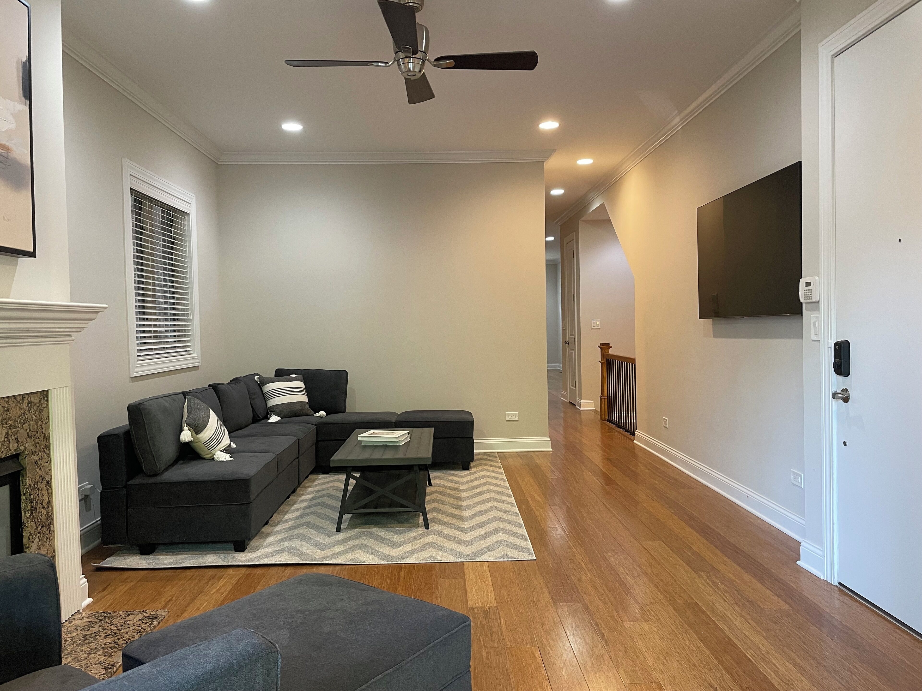 A modern living room with a sectional sofa, a coffee table, and a fireplace.